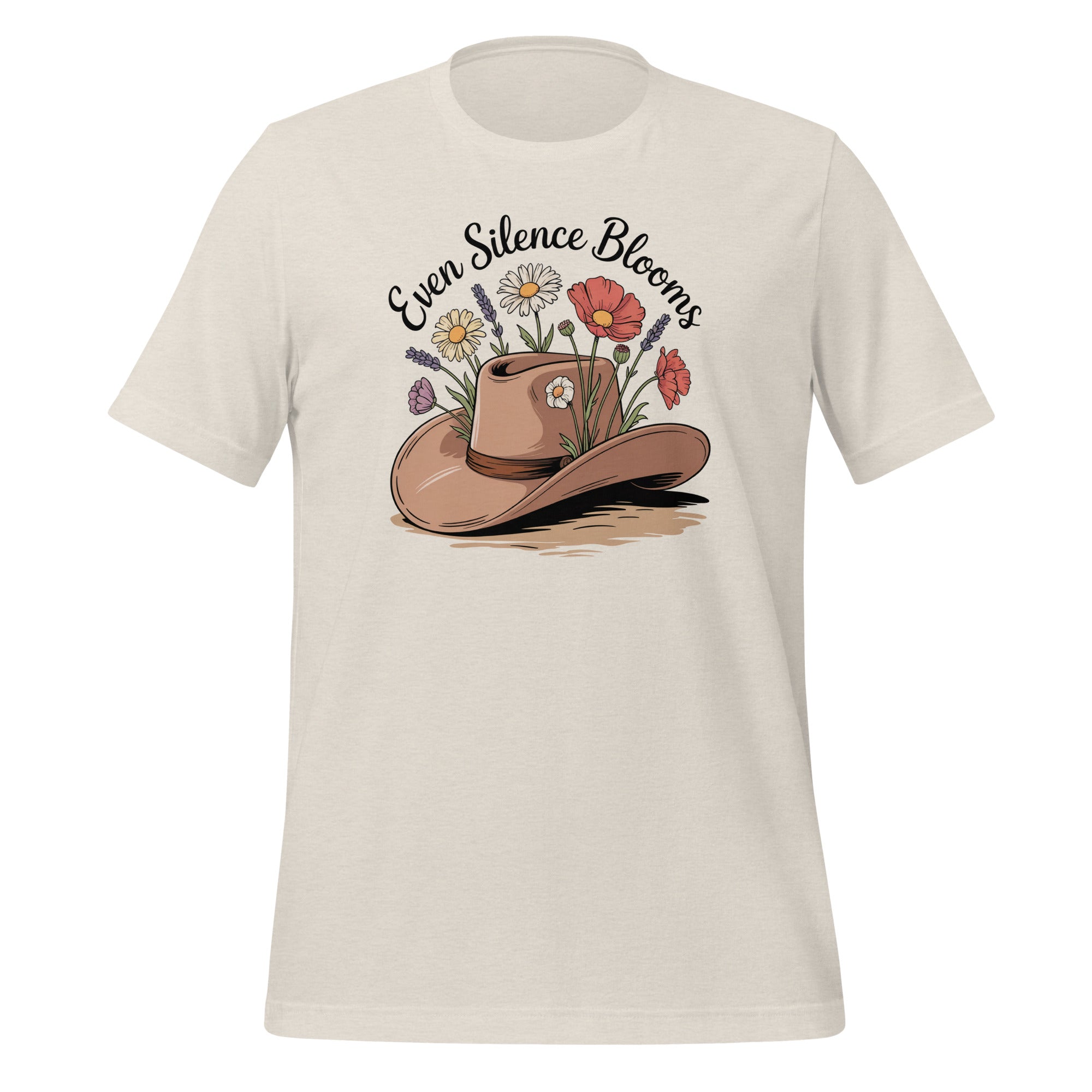 T-shirt unisexe beige avec un design bohème d’un chapeau de cowboy rempli de fleurs (lavandes, coquelicots, marguerites) et le texte "Even Silence Blooms".