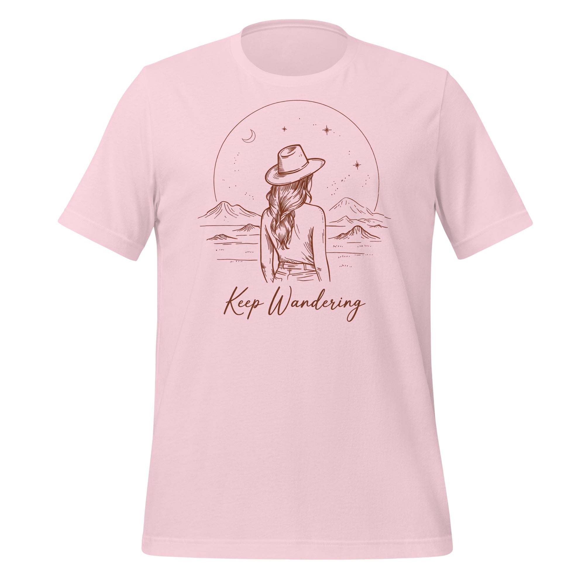 T-shirt unisexe rose pâle avec un design bohème d’une femme de dos avec chapeau, un paysage montagneux, une lune croissante, des étoiles et le texte "Keep Wandering".