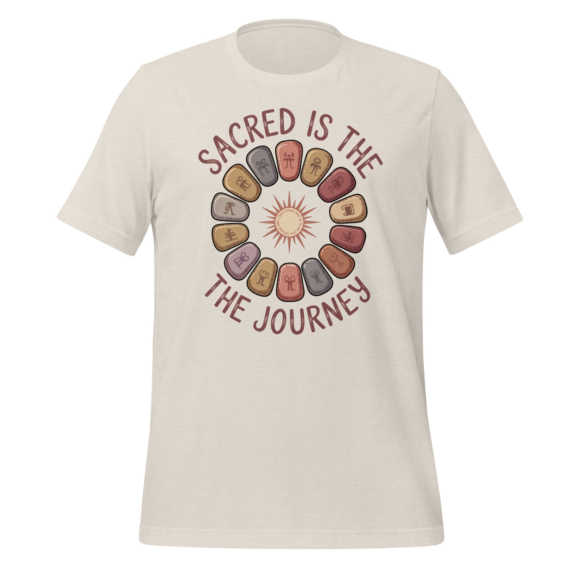 T-shirt unisexe beige avec un design bohème d’un soleil entouré de symboles runiques sur des pierres, et le texte "Sacred is the Journey" en tons brun-rouge.