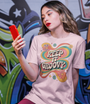 Femme en t-shirt rose Keep It Groovy devant un mur de graffiti coloré
