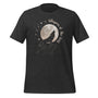 T-shirt unisexe gris foncé avec un design bohème d’un loup hurlant sur un rocher, une pleine lune, des étoiles et le texte "Whispers of the Wind".