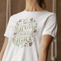 Une femme portant un tee-shirt blanc avec l’inscription "Grow With Grace" entourée de motifs floraux et de lunes, devant un fond beige texturé, pour HappyAndShiny.com.