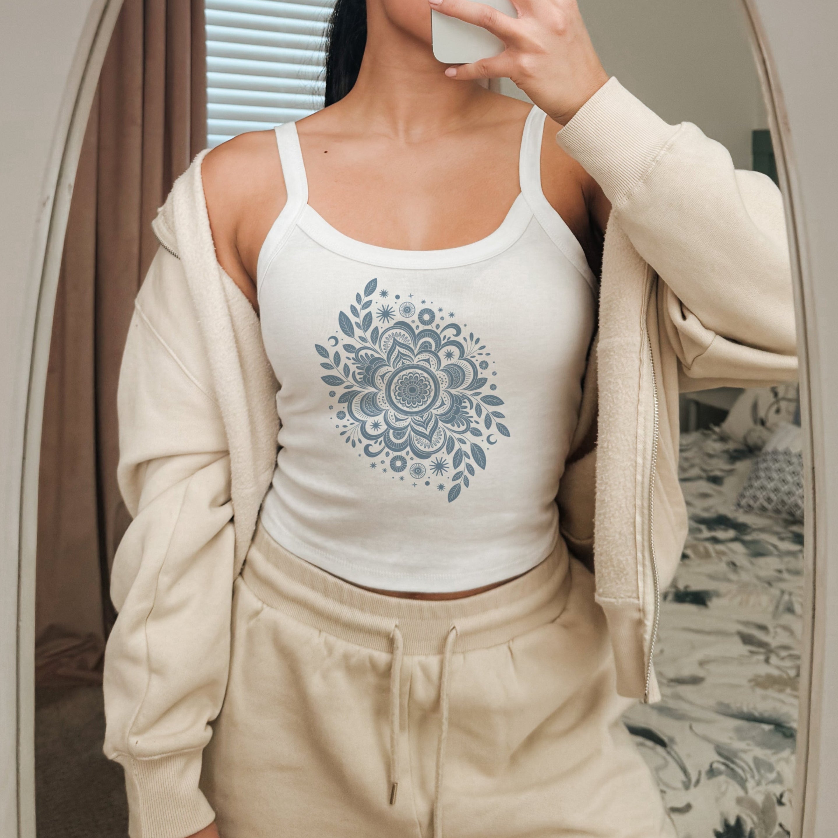 Débardeur blanc avec mandala floral et étoiles grises, style spirituel et élégant.
