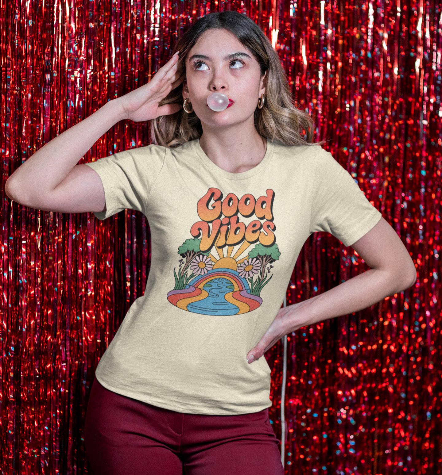 Femme en t-shirt beige Good Vibes devant un rideau de paillettes rouges