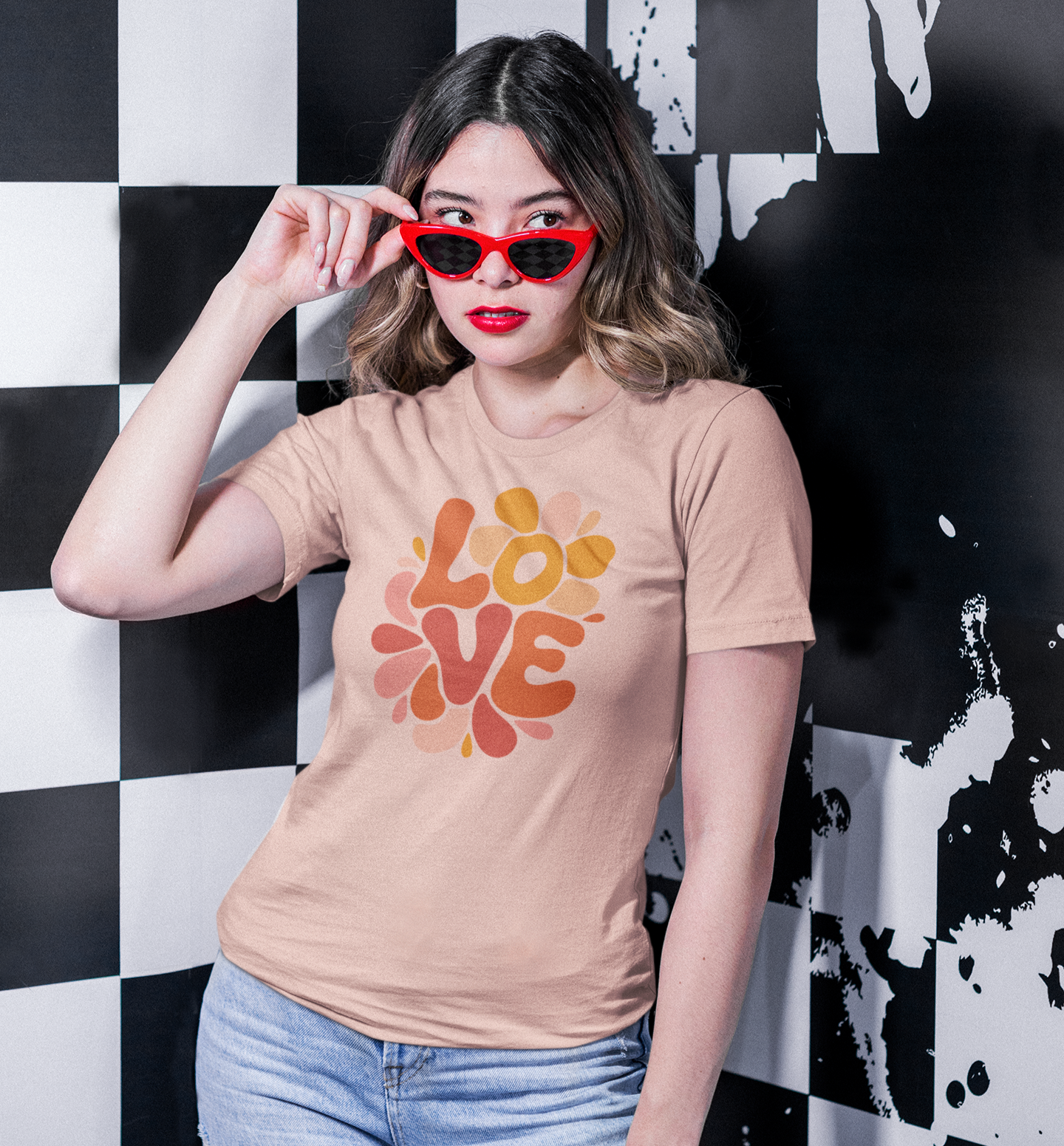 Femme en t-shirt beige Love avec lunettes rouges devant un fond à damier noir et blanc