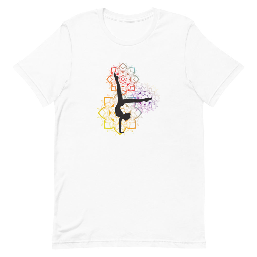T-shirt blanc unisexe avec un design vibrant affichant une silhouette noire en pose de yoga avancée (pied derrière la tête), entourée de trois mandalas colorés (rose, violet, jaune, orange, bleu) avec motifs géométriques.