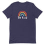 T-shirt bleu marine unisexe avec un design positif d’arc-en-ciel multicolore et l’inscription "Be Kind" en blanc.
