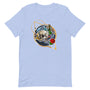 T-shirt bleu pâle unisexe avec un design bohème d’un crâne blanc et noir entouré d’un colibri bleu et vert, de fleurs rouges et blanches, et de plumes multicolores, encadré d’un cercle doré.