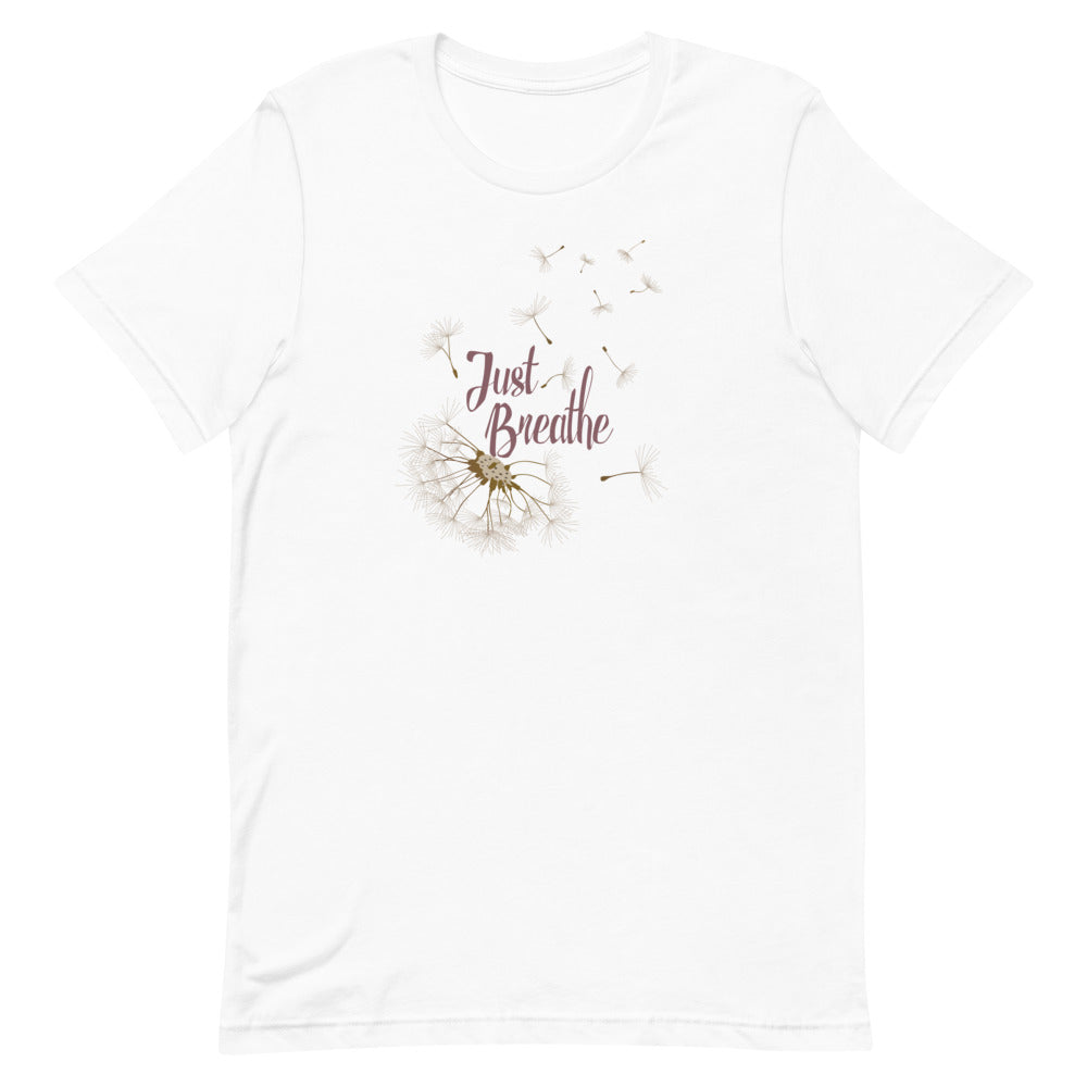 T-shirt blanc unisexe avec un design bohème de pissenlit beige et l’inscription "Just Breathe" en rose.