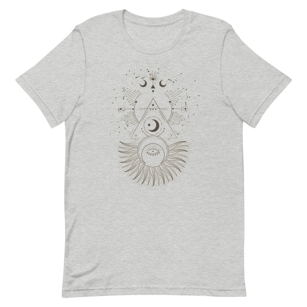 T-shirt gris clair unisexe avec un design bohème d’un soleil et d’une lune superposés en beige et marron, entourés de motifs géométriques comme des triangles, des rayons et des étoiles.