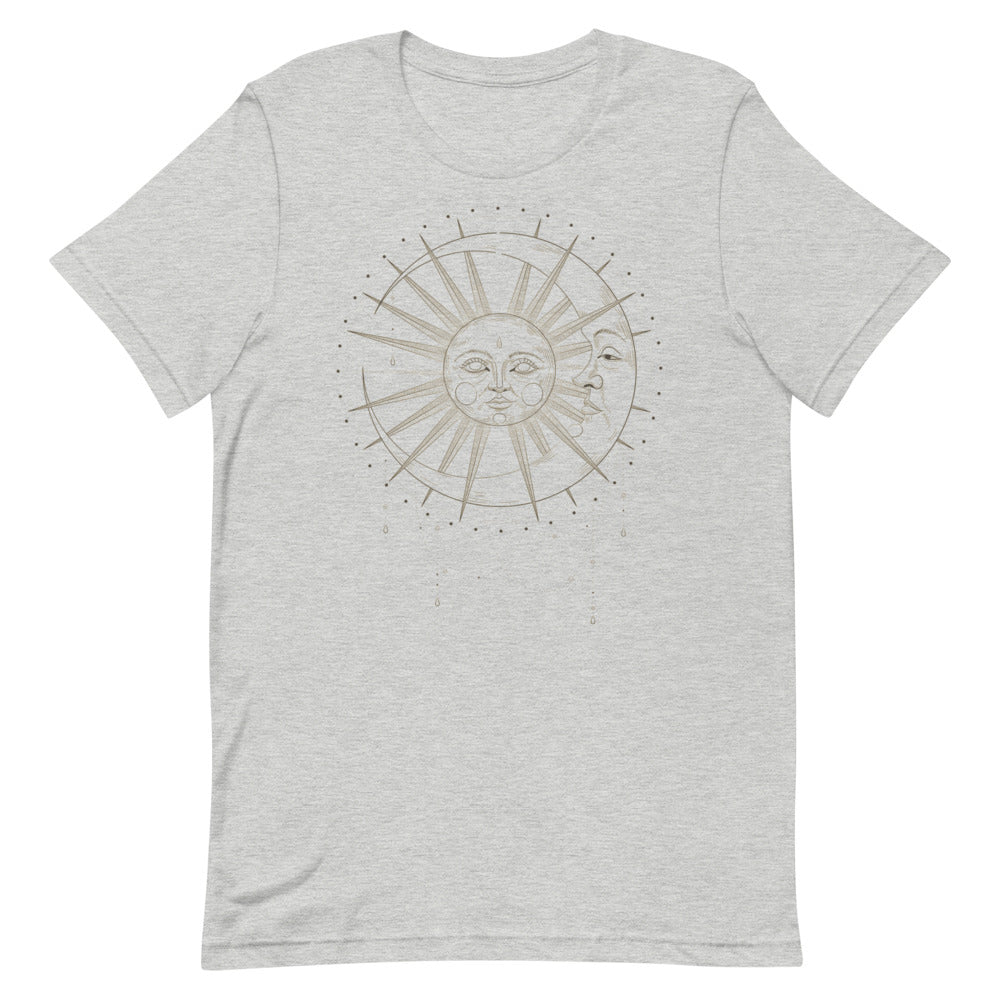 T-shirt gris clair unisexe avec un design bohème représentant un soleil et une lune entrelacés, dans des tons dorés et beiges, entourés de détails cosmiques subtils.