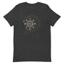 T-shirt gris foncé unisexe avec un design bohème d’un soleil beige et doré orné d’un visage, entouré de phases lunaires et de motifs célestes comme des étoiles et des rayons.