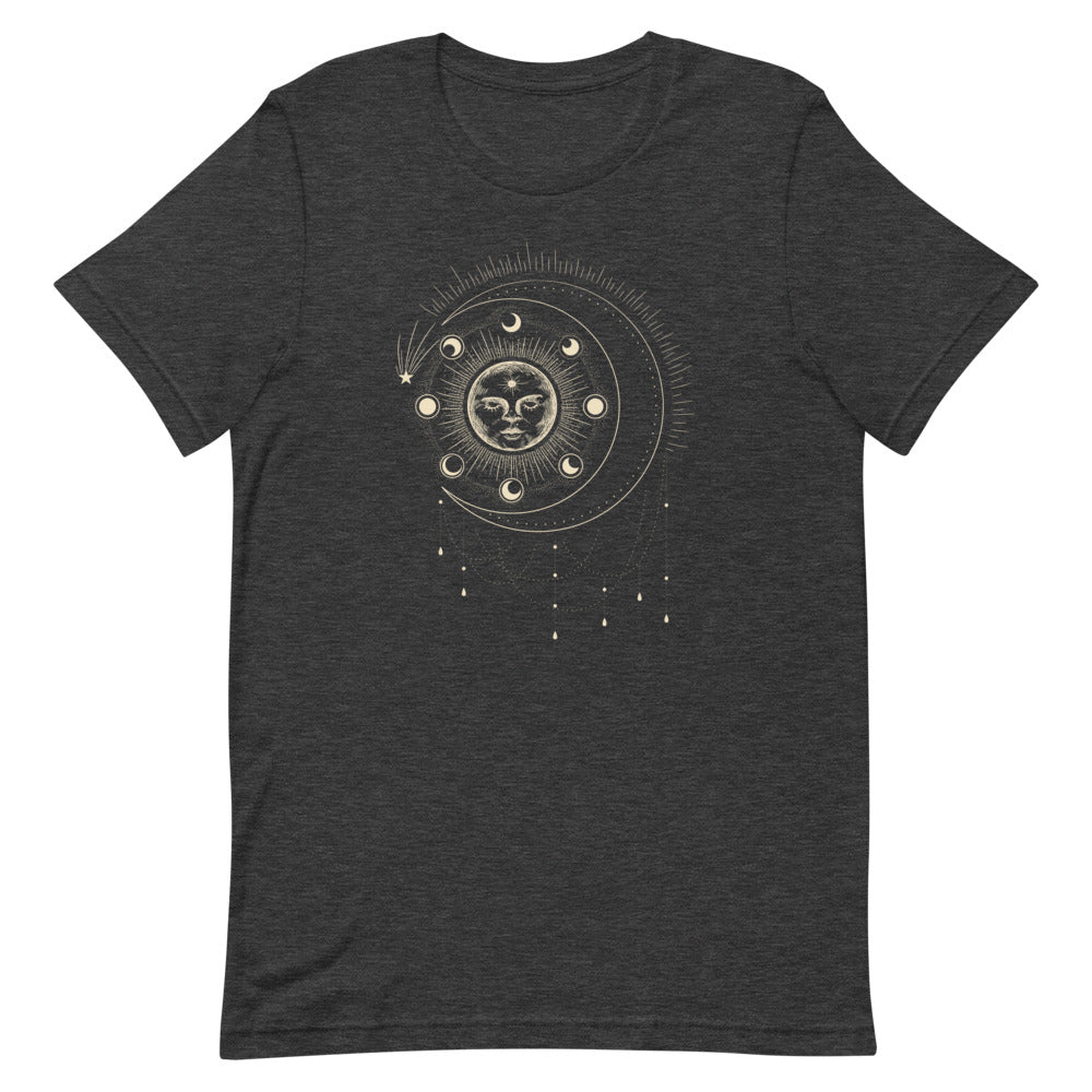 T-shirt gris foncé unisexe avec un design bohème d’un soleil beige et doré orné d’un visage, entouré de phases lunaires et de motifs célestes comme des étoiles et des rayons.