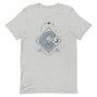 T-shirt gris clair unisexe avec un design bohème de vagues bleues encadrées d’un motif géométrique noir, accompagnées de deux lunes et de petits points évoquant des étoiles.
